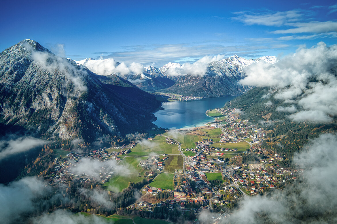 Luftaufnahme der Region Achensee in Tirol mit Blick auf den See, die umliegenden Berge und Ortschaften.