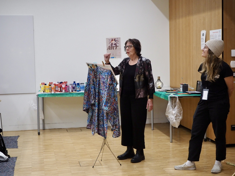 Thea Barth steht vor der Gruppe im Raum