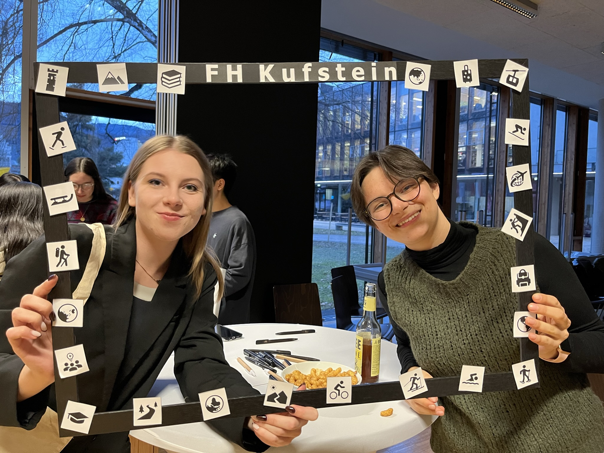 Zwei Austauschstudierende halten einen gebastelten Bilderrahmen 