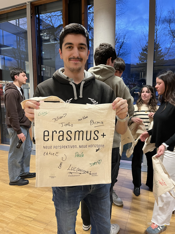 Austausschstudent hält Stoffbeutel in die Kamera