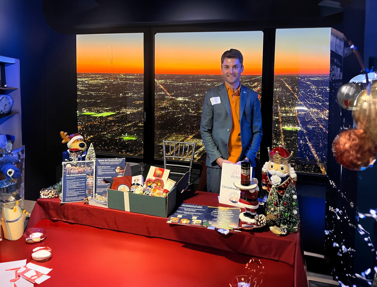 Toni Pötzl vor einem Messestand mit Blick auf die Stadt bei Nacht