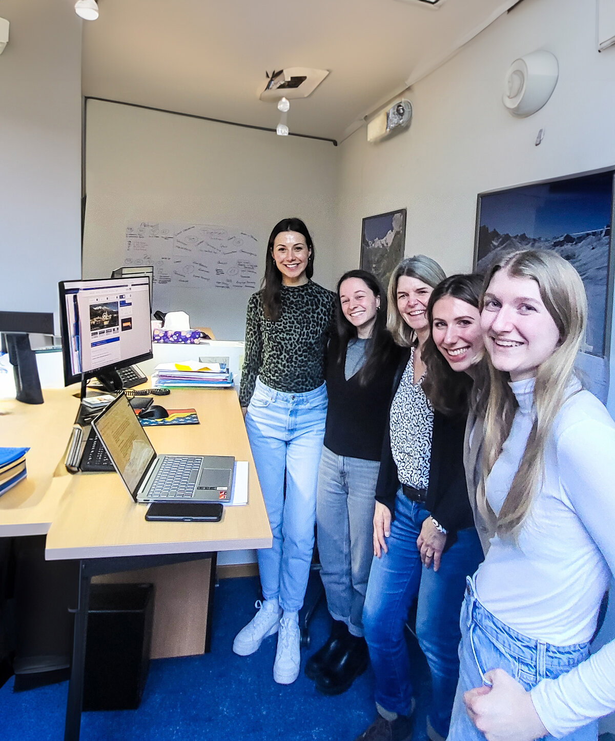 Studentinnen vor dem Schreibtisch mit Ines Zitturi