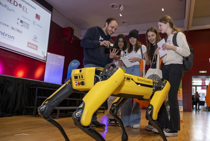 Mädchen bestaunen Robo-Hund am Girls! TECH UP Day an der HOK. 