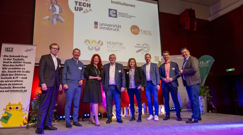 Organisatoren und Hosts des Girls! TECH UP Day auf der Bühne im Festsaal der HOK. 