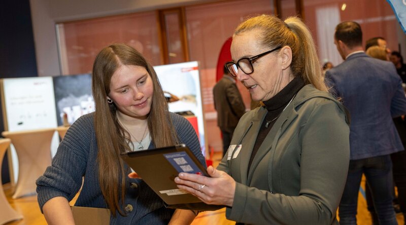 Mädchen im Gespräch mit Ausstellerin beim Girls! TECH UP Day. 