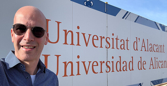 Peter Dietrich vor dem Eingangsschild der Universität