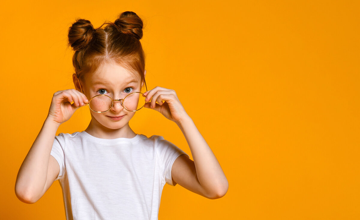 Kind mit Brille vor orangenem Hintergrund