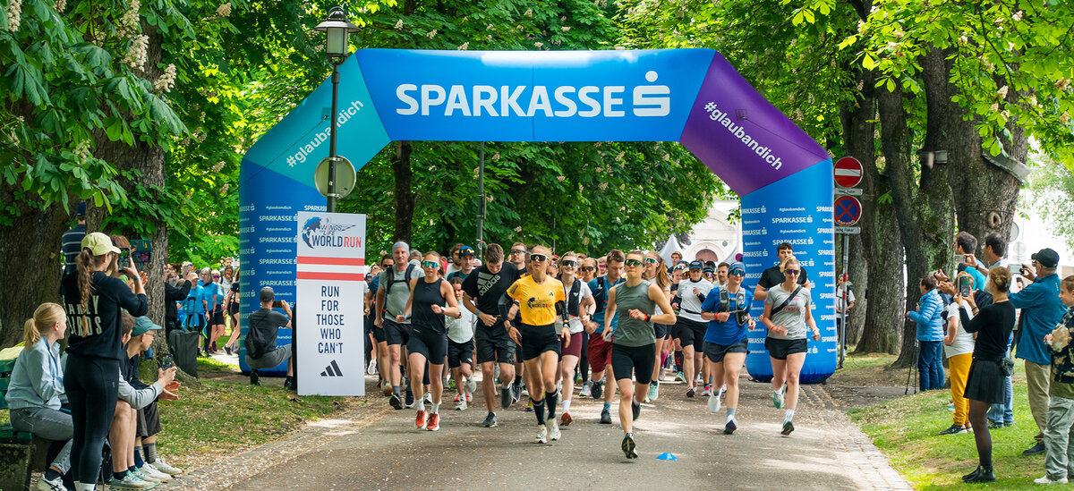 Auf einem Weg im Innsbrucker Park ist der Start mit laufenden Teilnehmenden.