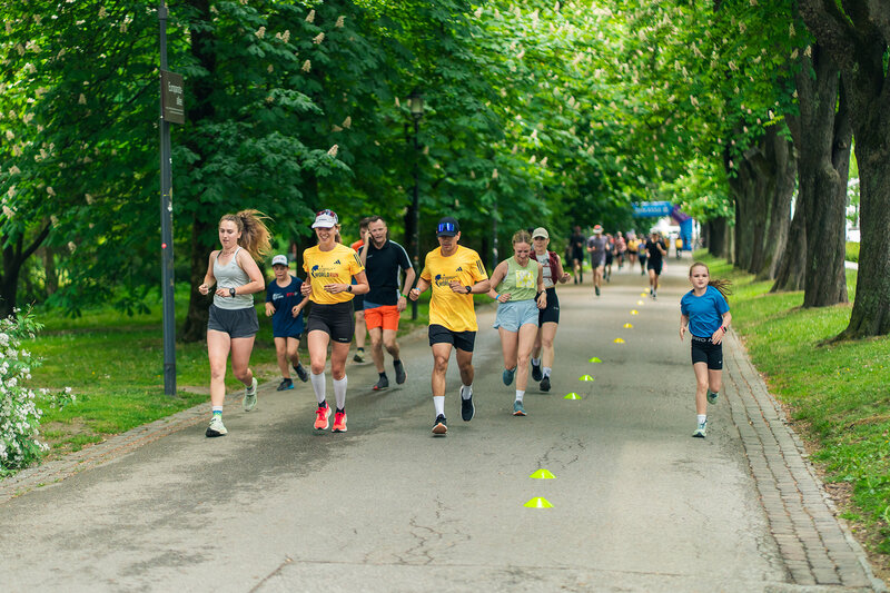 Mehrere Läufer:innen kurz nach dem Start im Hintergrund noch das Sparkassen-Start/Zielbogen