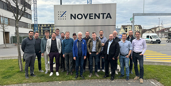 Personen stehen vor dem Firmenschild im Außenbereich von Noventa.