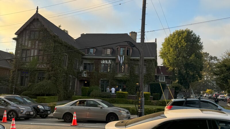 Historisches Fraternity-Haus in San Francisco, teilweise mit Efeu bewachsen, davor parken Autos.