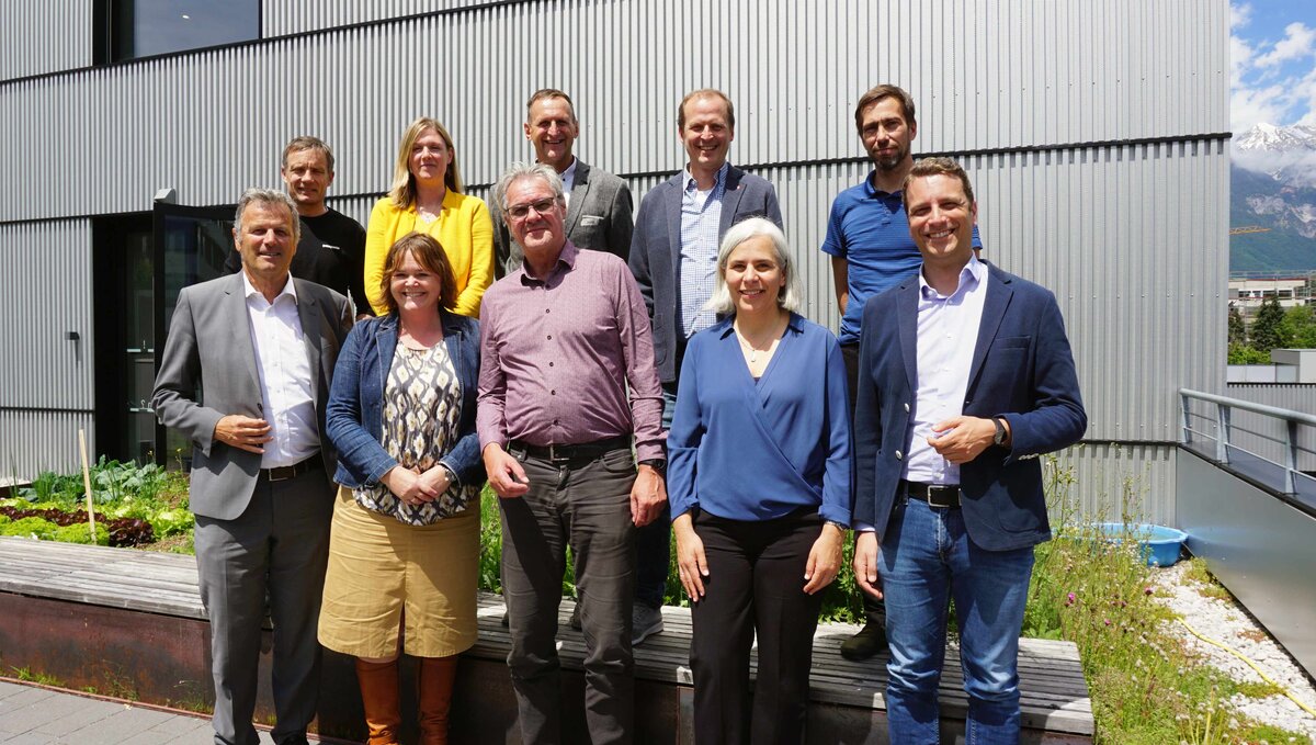 Personen stehen in drei Reihen zu einem Gruppenfoto zusammen