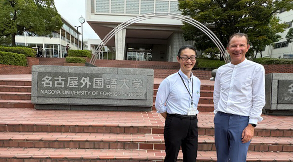 FH-Geschäftsführer Prof. (FH) Dr. Thomas Madritsch und Masamine Tamai vor einer roten Steinstiege der japanischen Partnerhochschule Nagoya University.