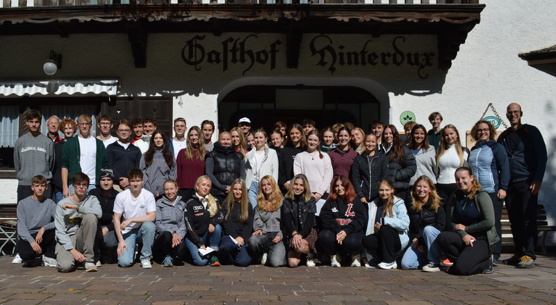 Große Gruppe von Studierenden und Lehrenden des Studiengangs International Business Management steht für ein Gruppenfoto vor dem Gasthof Hinterdux.