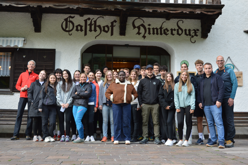 Gruppe von Studierenden und Lehrenden des Studiengangs International Business Management steht vor dem Gasthof Hinterdux für ein Gruppenfoto zusammen.