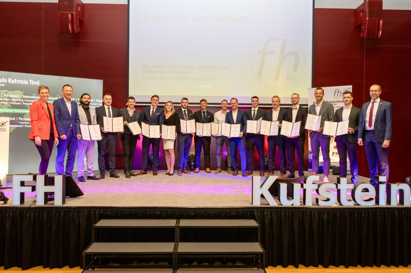 Gruppenfoto General-Management-MBA-Spondierende auf dem Podium des Festsaals der HOK. 