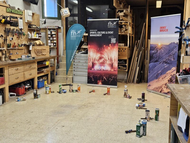 Ein Roll-up der HOK steht in einem Werkraum.