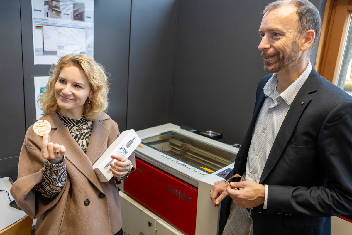 Bundesministerin Eva-Maria Holzleitner erhält im Makers Lab der HOK personalisierte Geschenke von Laborleiter Markus Ehrlenbach.