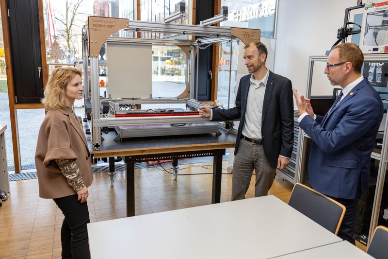 Bundesministerin Eva-Maria Holzleitner im Gespräch mit Laborleiter Markus Ehrlenbach und FH-Rektor Mario Döller im Makers Lab der HOK.