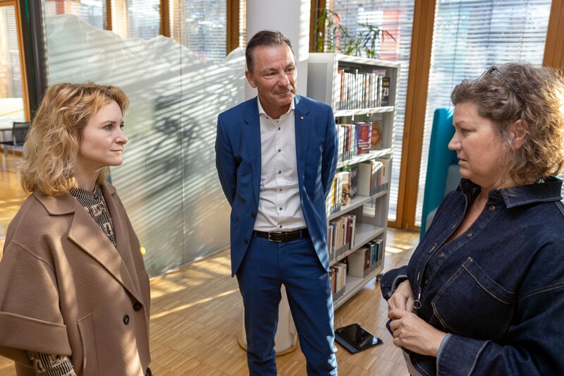 Bundesministerin Eva-Maria Holzleitner im Gespräch mit Bibliotheksassistentin Silke Lasta und FH-Geschäftsführer Thomas Madritsch in der kubi – Kufstein Bibliothek für Wissenschaft und Freizeit.