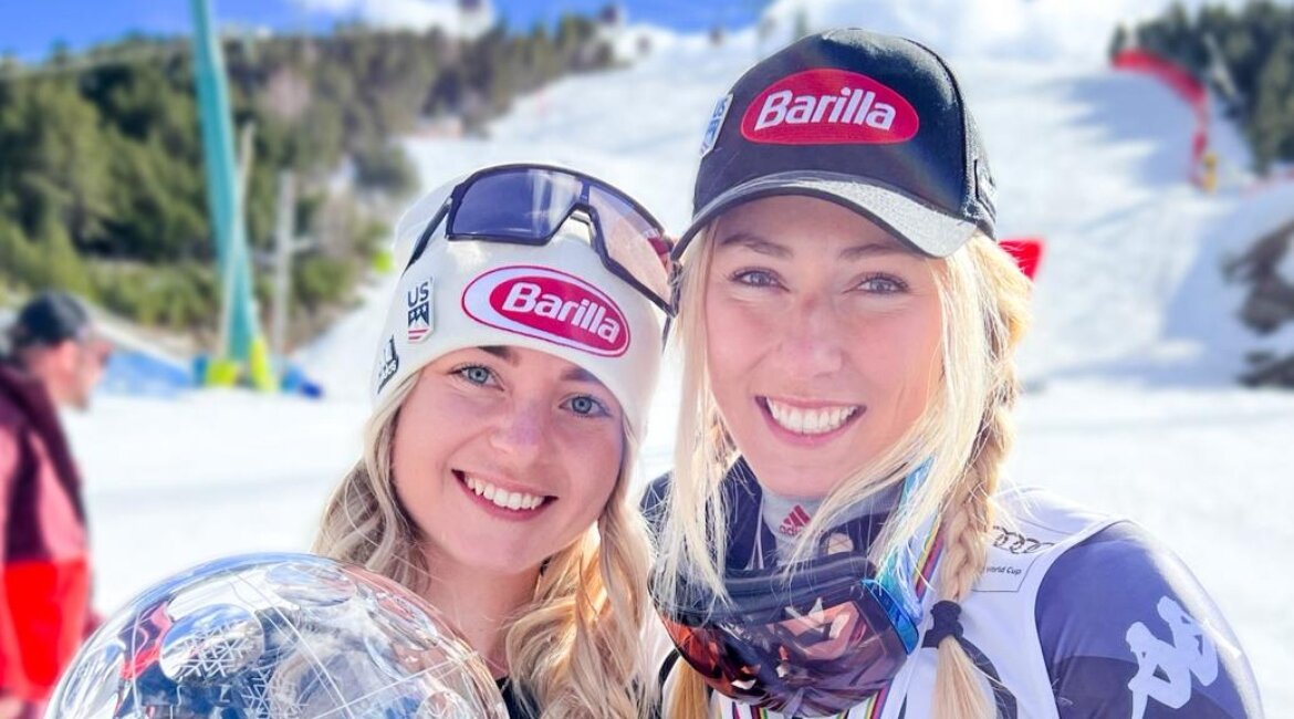 Gina Salevsky und Mikaela Shiffrin lehnen ihre Köpfe aneinander und lachen in die Kamera.