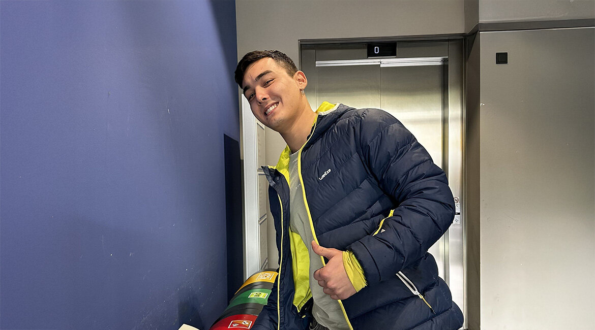 Ruben Hauser steht vor Müllcontainern und wird eine Verpackung in den Restmüll.