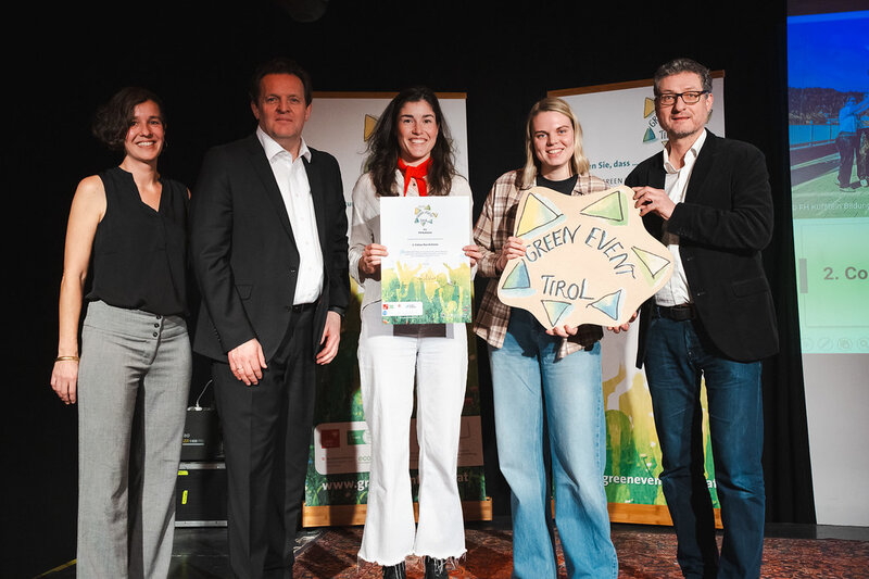 Für ein Gruppenfoto stehen Stephanie Rauscher, LR René Zumtobel, Tabea Dietrich und Ninke Holtmaat (SKVM.vzM.24, HOK), stellvertretend für die 2. Colour Run Kufstein, Andrä Stigger.auf einer Bühne nebeneinander und halten ihre Auszeichnungen in die Kamera.
