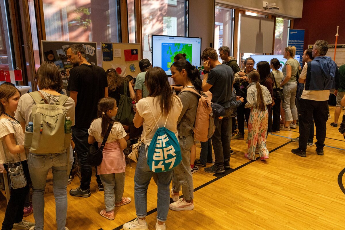 Besucherinnen erkunden den Festsaal der Kufsteiner Hochschule bei der Langen Nacht der Forschung und informieren sich an verschiedenen Stationen 
