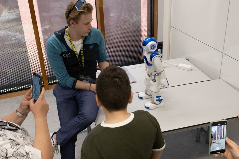 Roboter Nao wird bei der Langen Nacht der Forschung an der Kufsteiner Hochschule präsentiert und zeigt Besucher:innen die Möglichkeiten moderner Robotik.