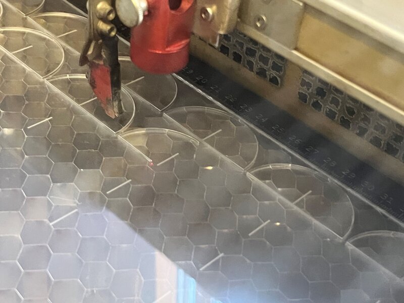 Nahaufnahme von einem Acrylglas, das im Lasercutter geschnitten wird.