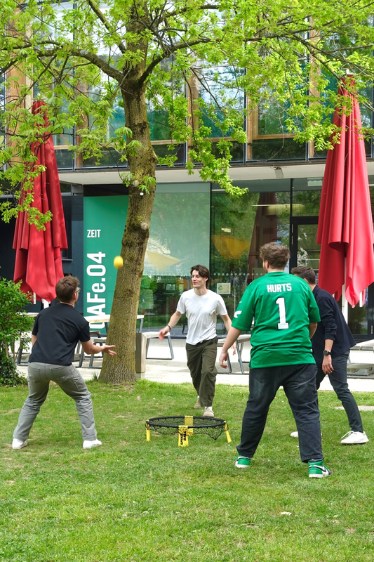 Personen spielen im Stadtpark Spike-Ball.