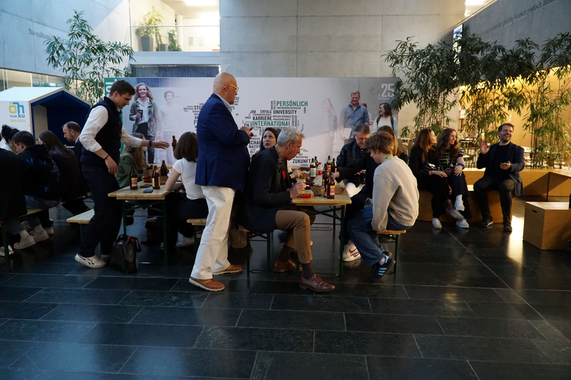 Teilnehmer:innen nehmen einen Snack zu sich in der Aula der HOK.