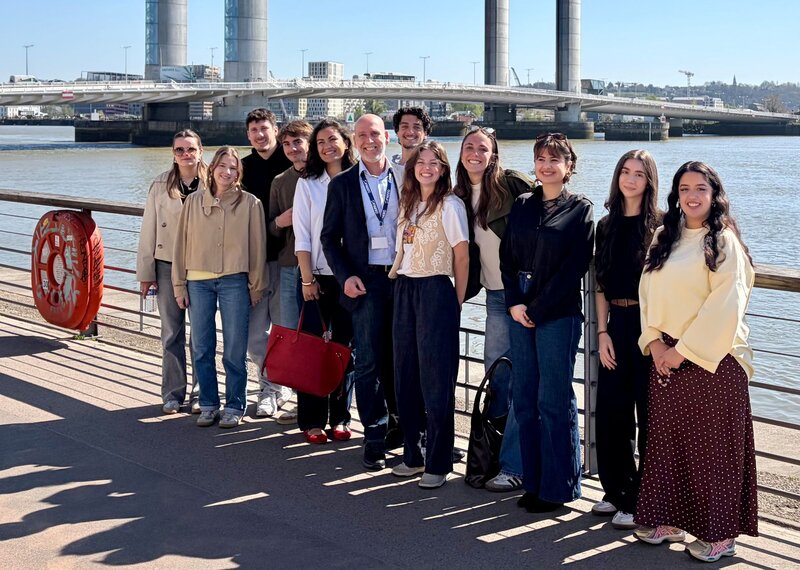 Prof. (FH) Dr. Bernd Wollmann mit Studierenden bei einer gemeinsamen Gruppenaufnahme an der Uferpromenade in Bordeaux, Frankreich.