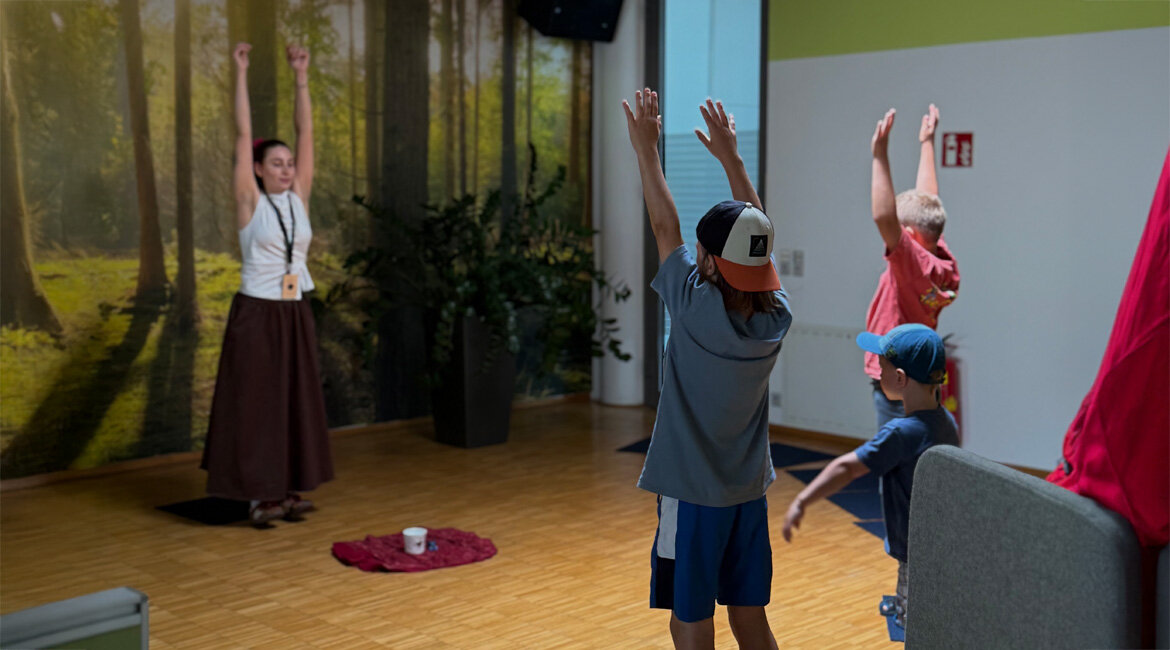 Kinder machen Entspannungs- und Achtsamkeitsübungen beim kubi Kinderliteraturfestival in der Bibliothek Kufstein.