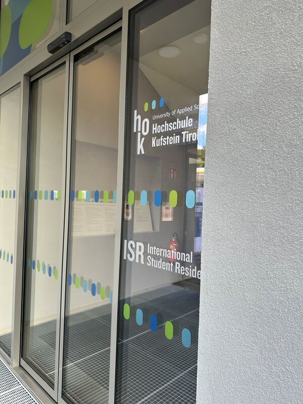 Blick auf die Eingangstür und die Beschriftung des neuen Studierendenwohnheims in Kufstein.