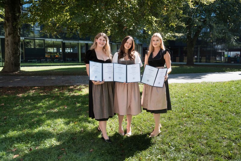 HOK-Spondierende zeigen ihre Abschlussurkunden auf dem Campus der HOK.