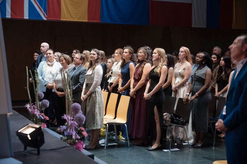 Studierende stehen im Festsaal auf und legen das akademische Gelöbnis ab.