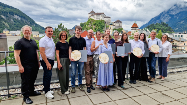 Stolze Preisträger:innen und Jurymitglieder mit Studiengangsleiter Asc. Prof. (FH) Dipl.-Ing. Christian Huber (ganz links) auf der HOK-Dachterrasse. | © HOK