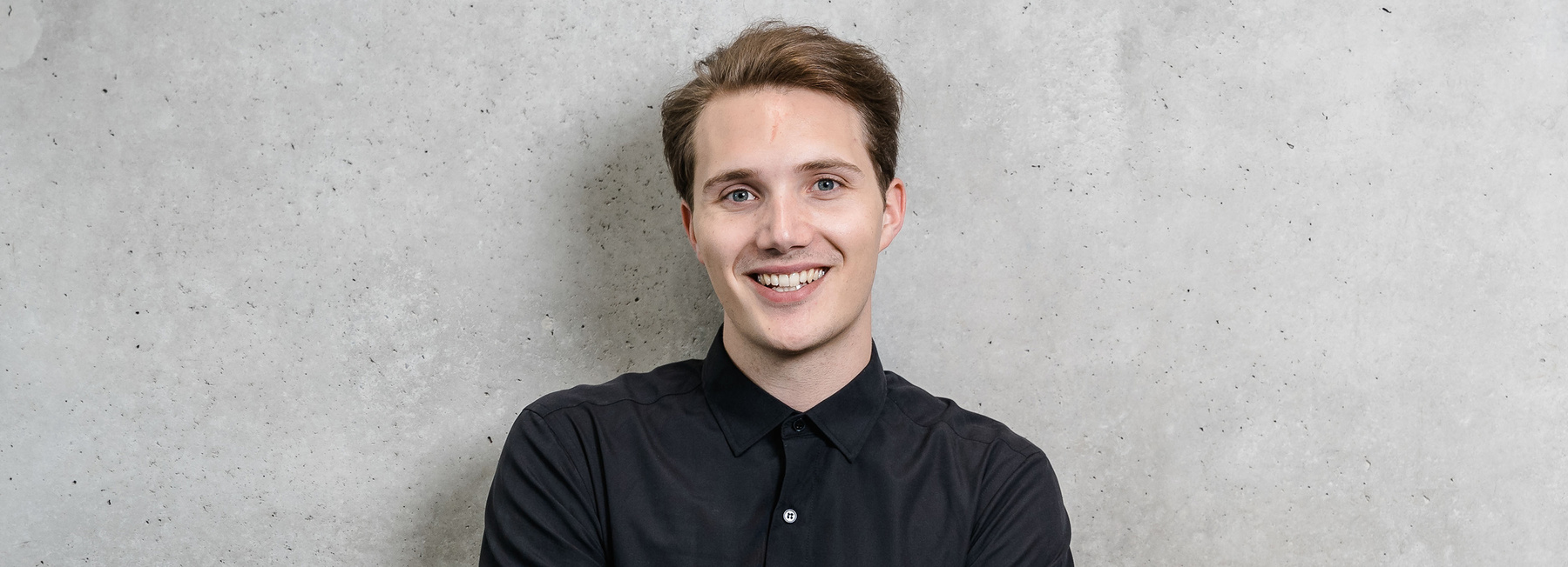Porträt eines lächelnden Studenten der Hochschule Kufstein für den Bachelorstudiengang Wirtschaftspsychologie & Management Vollzeit