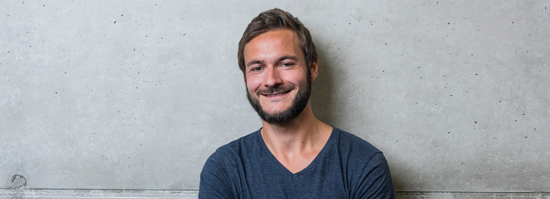 Porträt eines lächelnden Studenten der Hochschule Kufstein für den Bachelorstudiengang International Business Management berufsbegleitend
