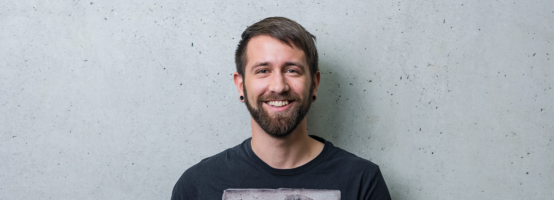 Porträt eines lächelnden Studenten der Hochschule Kufstein für den Bachelorstudiengang Sport-, Kultur- & Veranstaltungsmanagement Vollzeit
