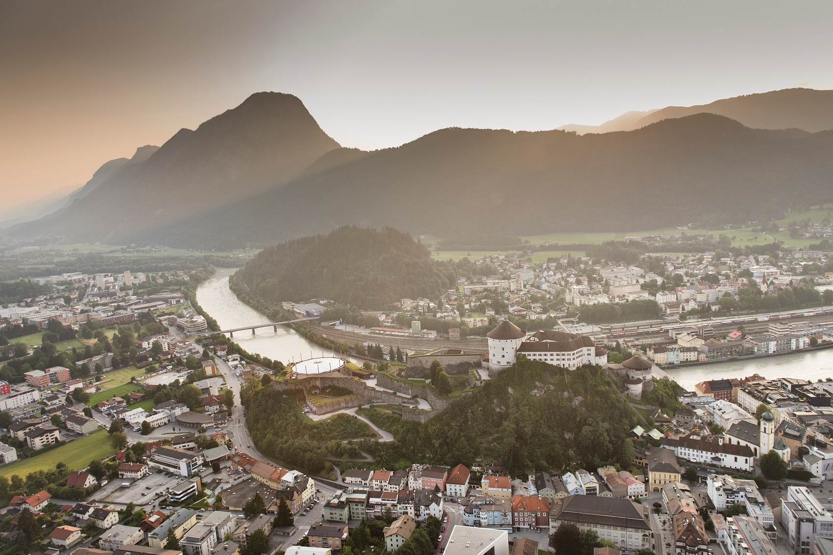 Luftaufnahme von Kufstein mit der Festung Kufstein, dem Inn und umliegenden Bergen bei Sonnenuntergang