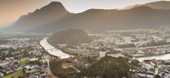 Luftaufnahme von Kufstein mit der Festung Kufstein, dem Inn und umliegenden Bergen bei Sonnenuntergang